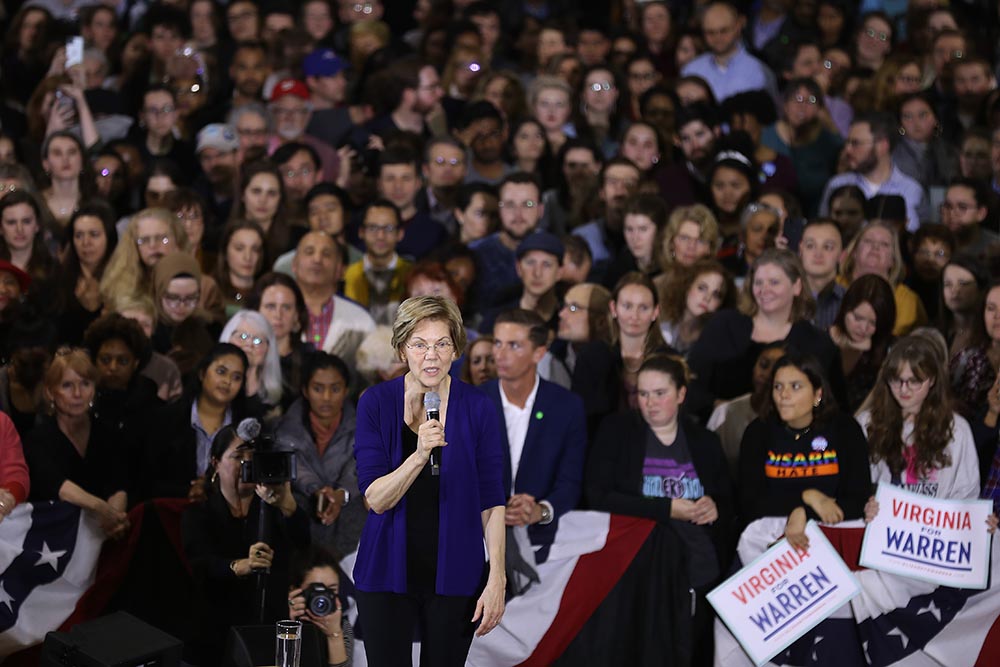 caption: Democratic presidential candidate Sen. Elizabeth Warren (D-MA) speaks during a campaign rally in the gymnasium at Wakefield High School February 13, 2020 in Arlington, Virginia. After placing fourth in both the Iowa caucuses and the New Hampshire primary, Warren is looking to regain traction heading into Nevada, South Carolina and the Super Tuesday contests. (Chip Somodevilla/Getty Images)