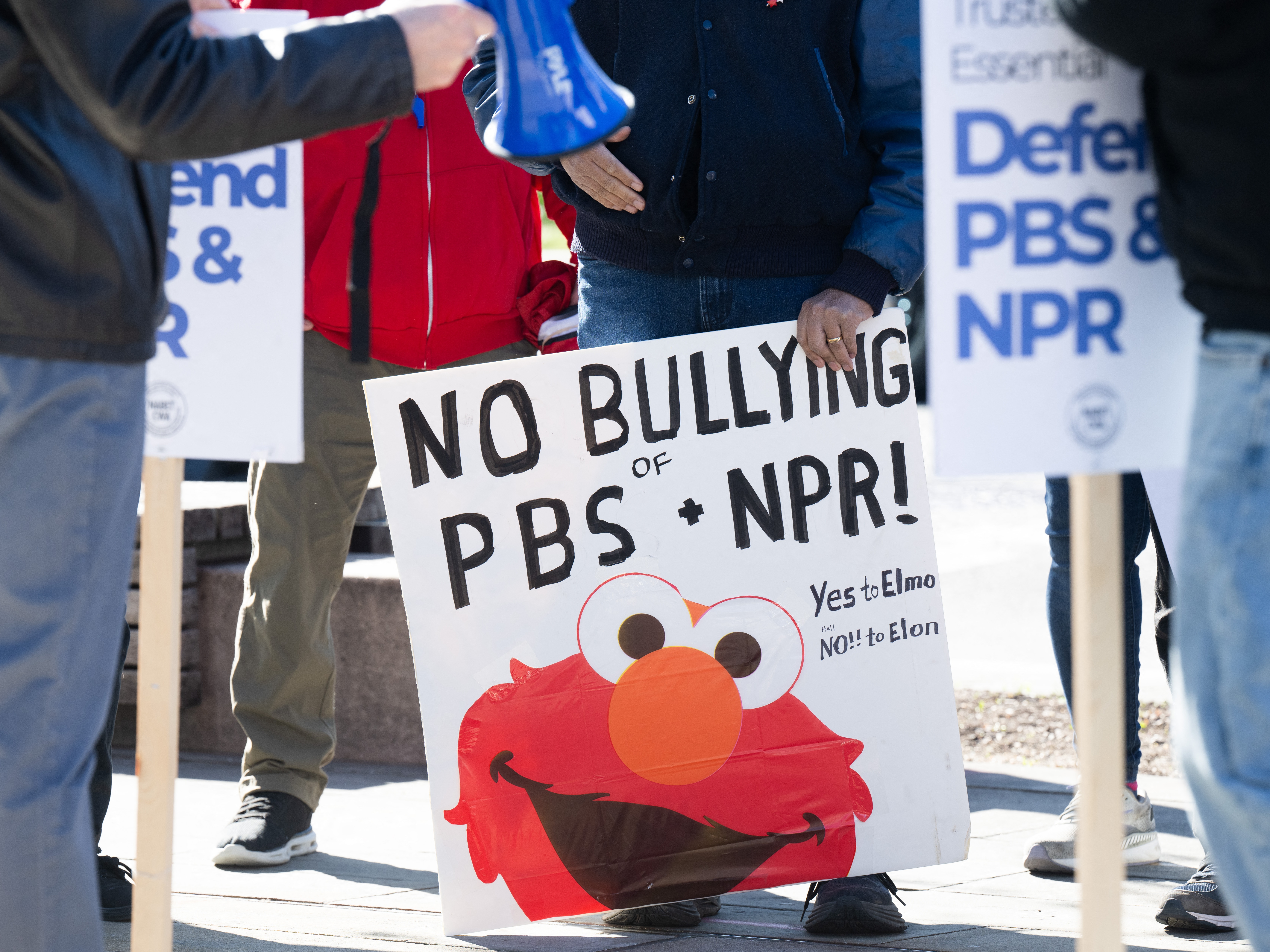 caption: People participate in a rally to call on Congress to protect funding for public broadcasters PBS and NPR outside the NPR headquarters in Washington, DC, on March 26, 2025.