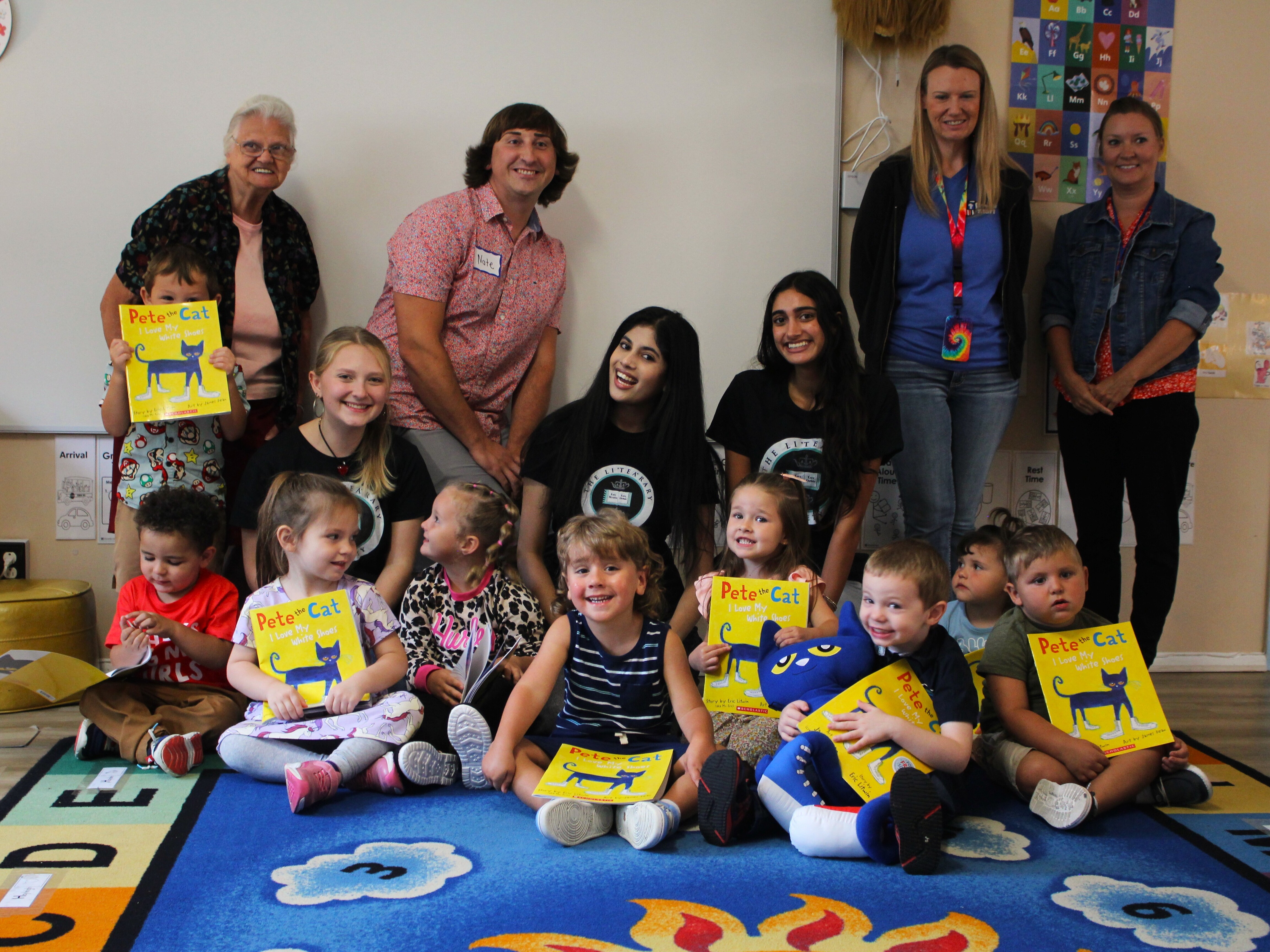 caption: Volunteers from the LiTEArary Society read and donate copies of <em>Pete the Cat: I Love My White Shoes</em> to pre-schoolers in Grafton, West Virginia. <br>