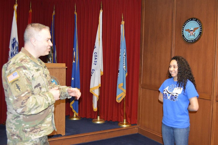 caption: Commander Lt. Col. Vylius Leskys administers the enlistment oath to Levani Ilasa, the first woman in the country to enlist on a combat tank crew.