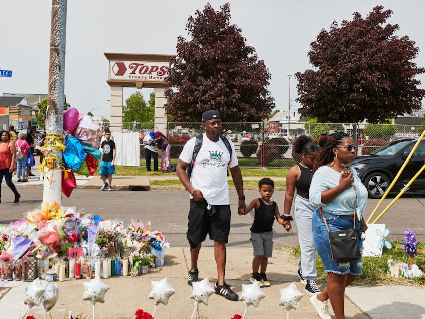 caption: Community members gather May 21 to support each other near the Tops market that was targeted in a racist mass shooting in Buffalo, N.Y.