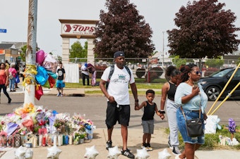 caption: Community members gather May 21 to support each other near the Tops market that was targeted in a racist mass shooting in Buffalo, N.Y.