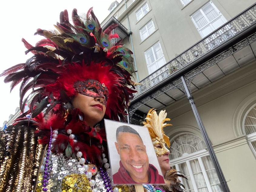 caption: Deanna Teasley and her friend and co-worker Caroline at Mardis Gras in New Orleans. They're holding a photo of their friend Demetrius, who died shorty before the trip (the cause was not COVID).