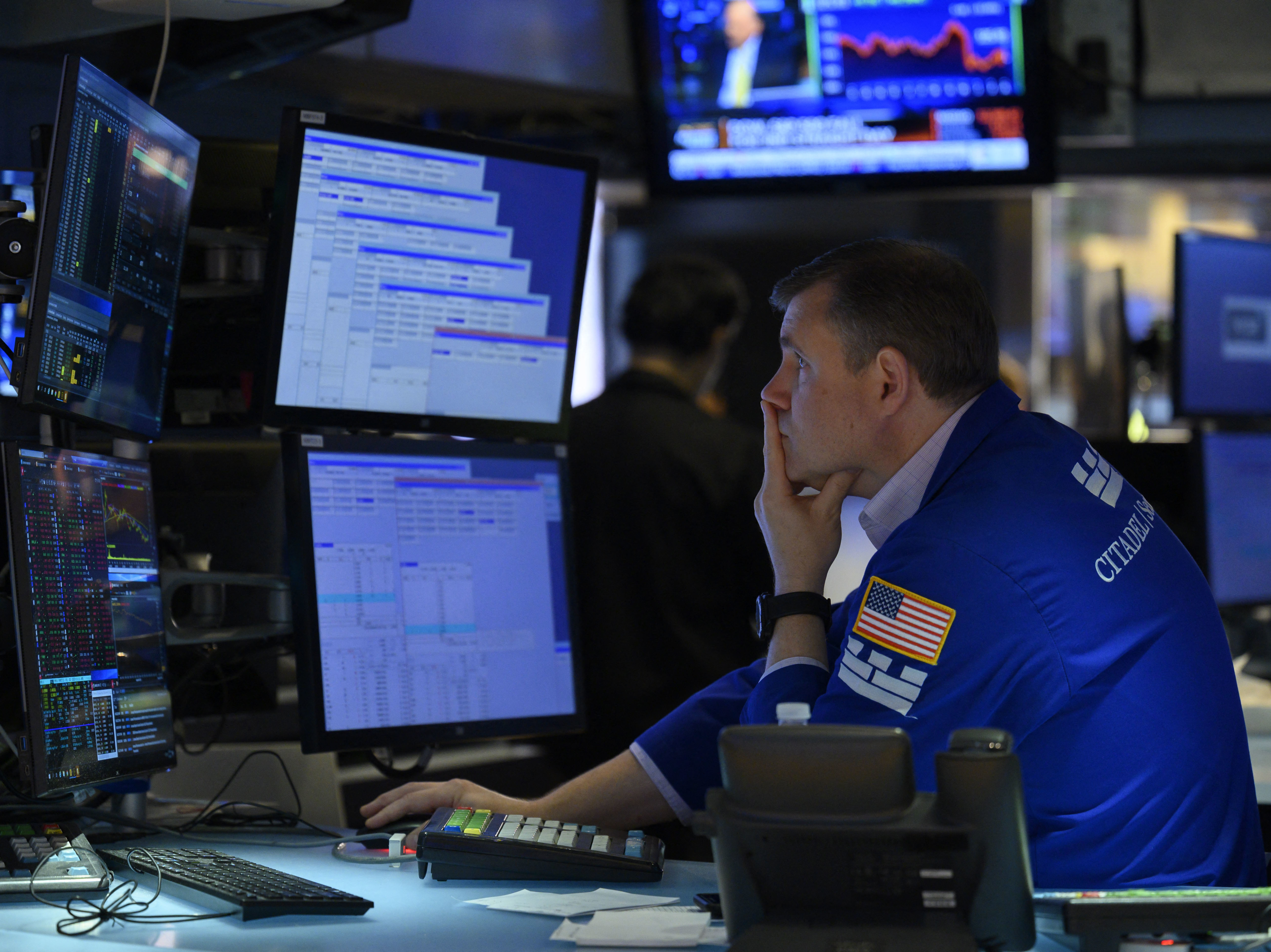 caption: A trader works on the floor of the New York Stock Exchange in New York City on Aug. 5. The majority of America's top companies have reported strong earnings, but warning signs about the economy are also emerging from their corporate earnings.