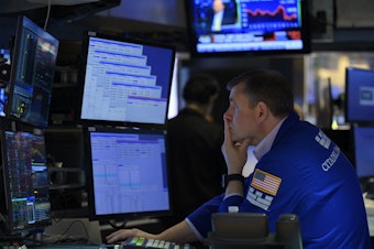 caption: A trader works on the floor of the New York Stock Exchange in New York City on Aug. 5. The majority of America's top companies have reported strong earnings, but warning signs about the economy are also emerging from their corporate earnings.