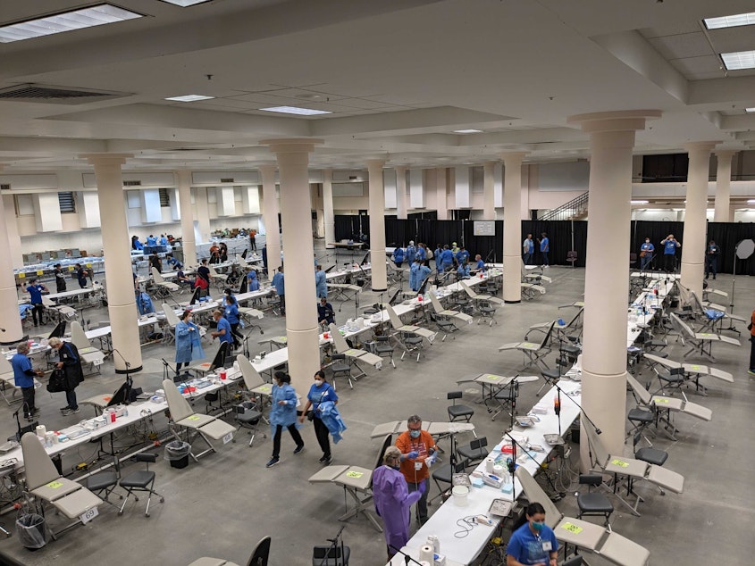 caption: Volunteers set up the dental area at Seattle Center on Thursday, April 27, 2023. Hundreds of people will receive free dental services here over four days as part of the Seattle/King County free clinic.