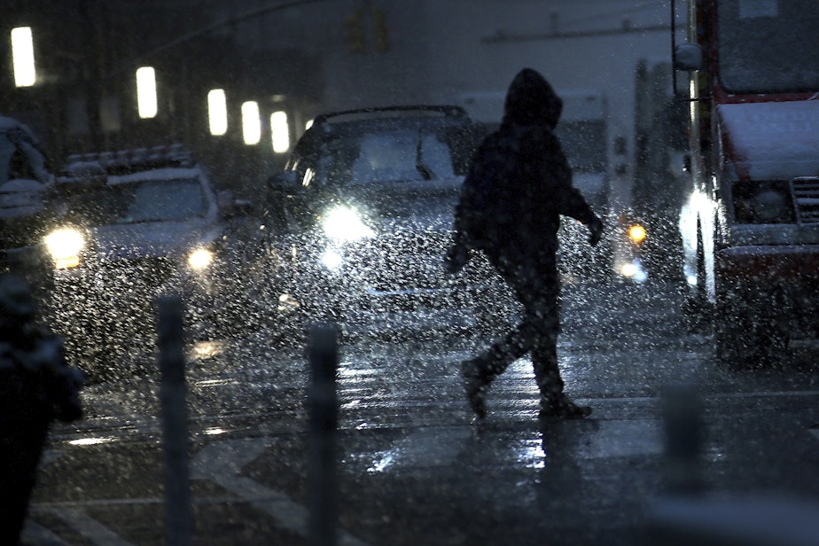 caption: A man is silhouetted by car headlights as he crosses the streets of lower Manhattan during a snow storm on Thursday, Nov. 15, 2018, in New York. (Wong Maye-E/AP)