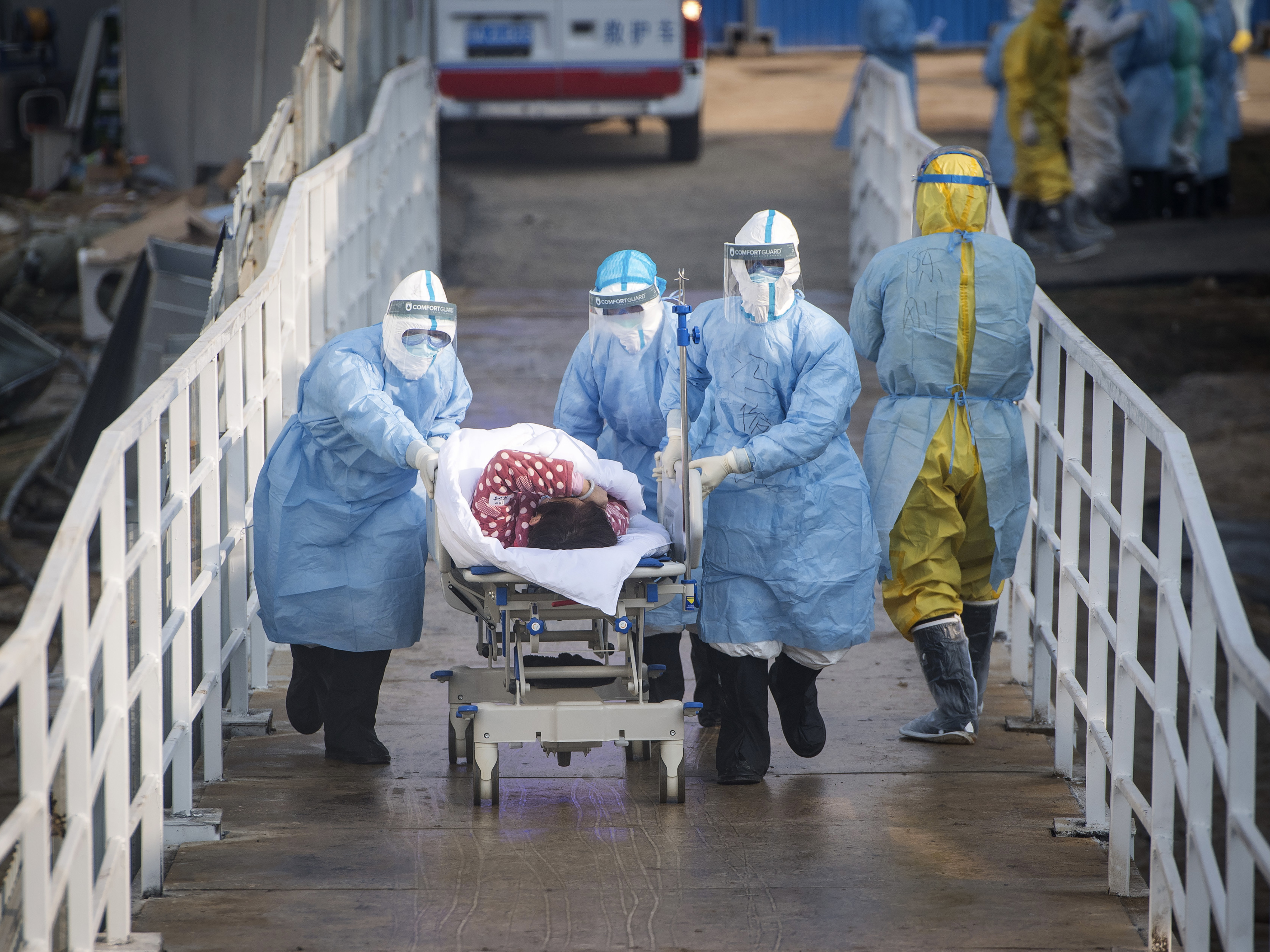 caption: In this photo released by China's Xinhua News Agency, medical workers in protective suits help transfer the first group of patients into the newly-completed Huoshenshan temporary field hospital in Wuhan in central China's Hubei province.