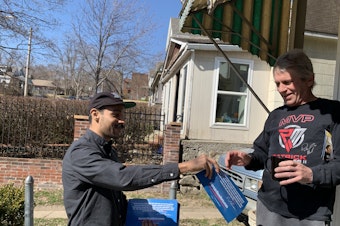 caption: Ricardo Flores, a volunteer for Bernie Sanders, hands John Rellihan a campaign flyer in North Kansas City, Mo., on Sunday. Sanders' supporters are making a big push for him to regain front-runner status.