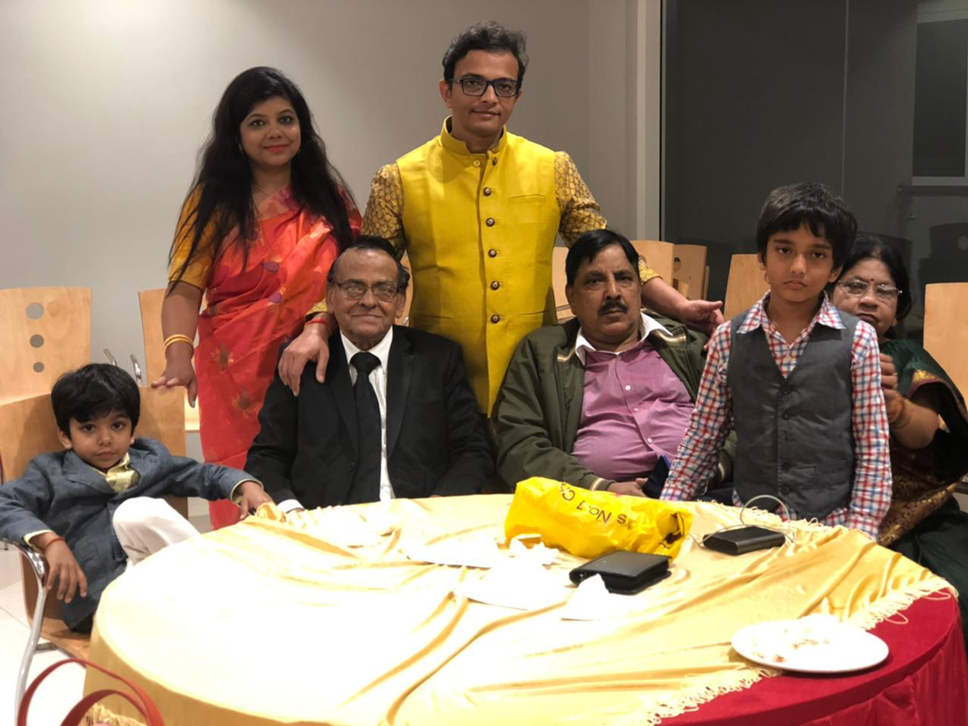caption: Richa Srivastava (rear left) with her husband, Shalabh Pradhan (rear right), and their two fathers, Sudheer Kumar Pradhan (front left) and Sheo Prakash Srivastava (front right), in an undated family photo. The two family patriarchs died within three days of one another in April.