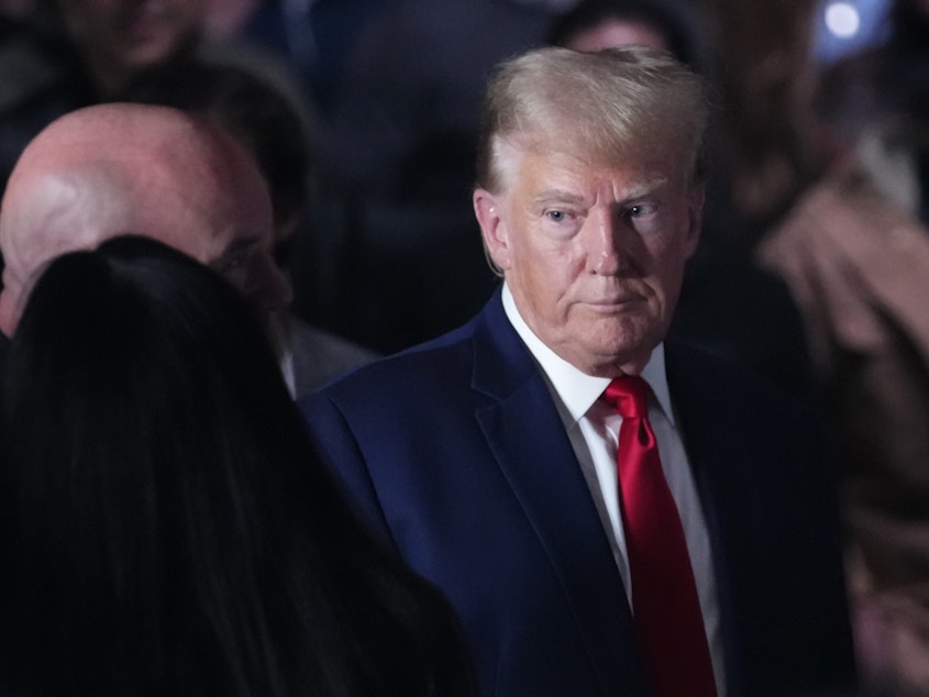 caption: Former President Donald Trump, shown here at a mixed martial arts event on Nov. 11, is asking to be freed from a gag order in an election interference case.