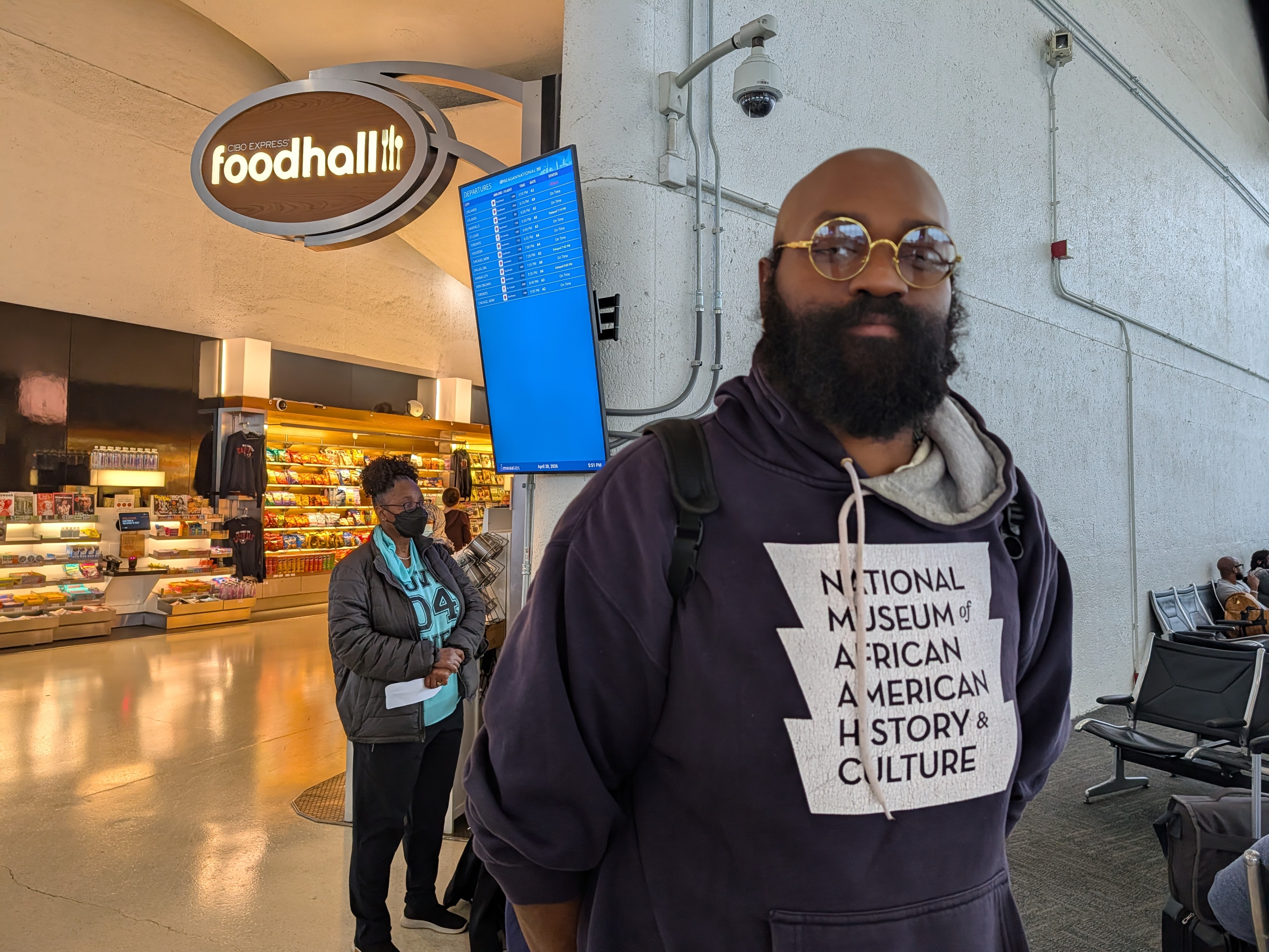 caption: Lee Collins waits for his flight back to Atlanta from Washington, D.C., on April 28. He is considering fewer flights to visit his family this year due to higher airfares.