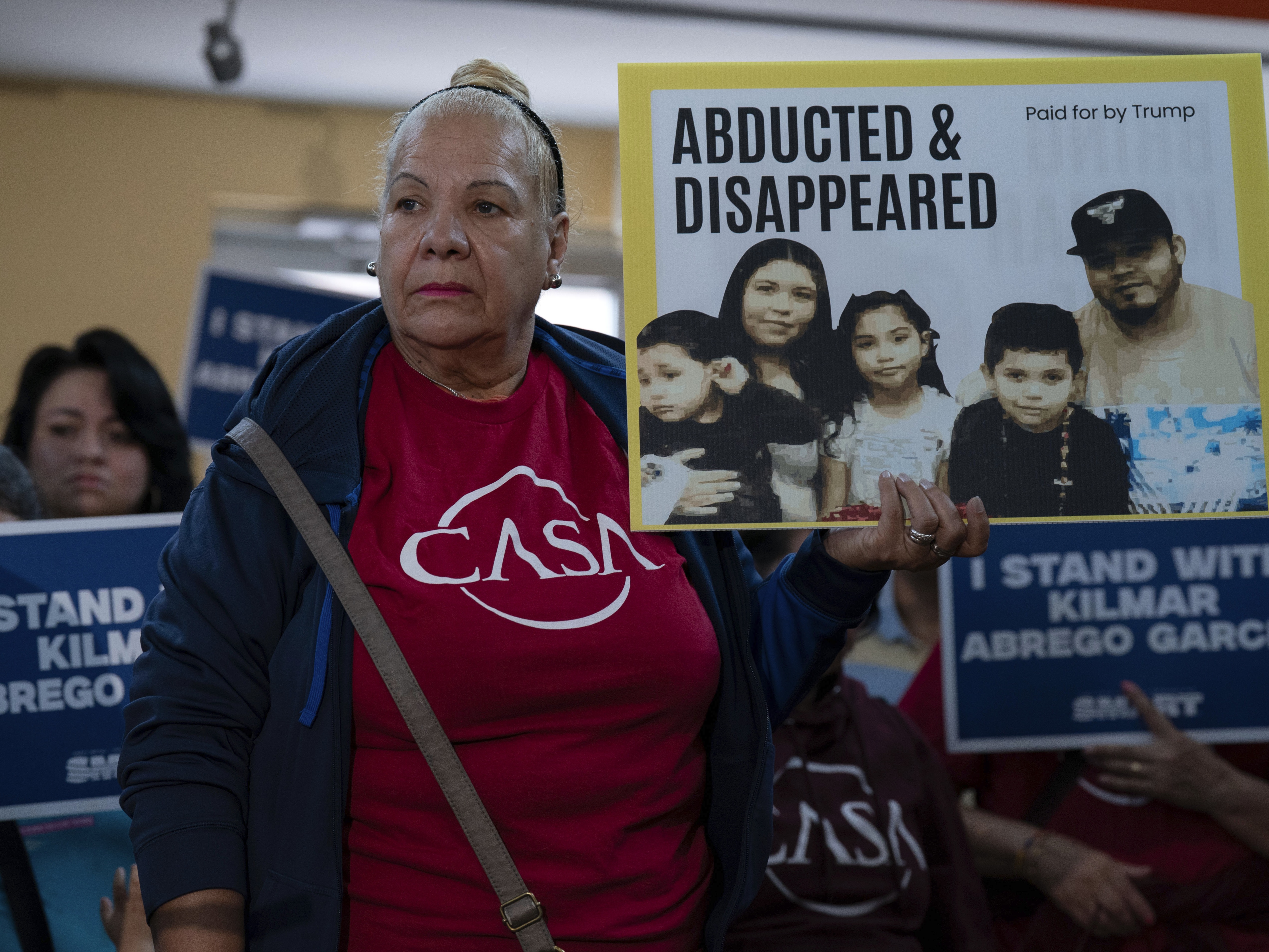 caption: Supporters hold up signs as Jennifer Vasquez Sura, the wife of Kilmar Abrego Garcia of Maryland, who was mistakenly deported to El Salvador, speaks during a news conference at CASA's Multicultural Center in Hyattsville, Md., Friday, April 4.