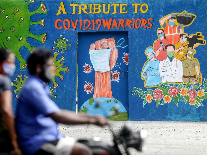 caption: A mural in Chennai, India, celebrates workers on the front lines against the coronavirus pandemic. The global case count crossed the 20 million threshold on Monday, with the U.S., Brazil and India in the lead.