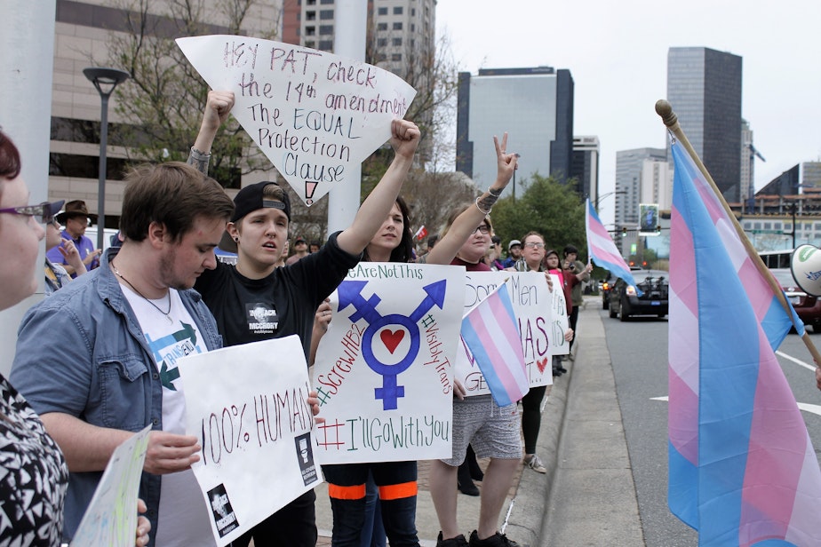 caption: Demonstrators protesting passage of legislation limiting bathroom access for transgender people stand in front of the Charlotte-Mecklenburg Government Center in Charlotte, N.C., Thursday, March 31, 2016. 