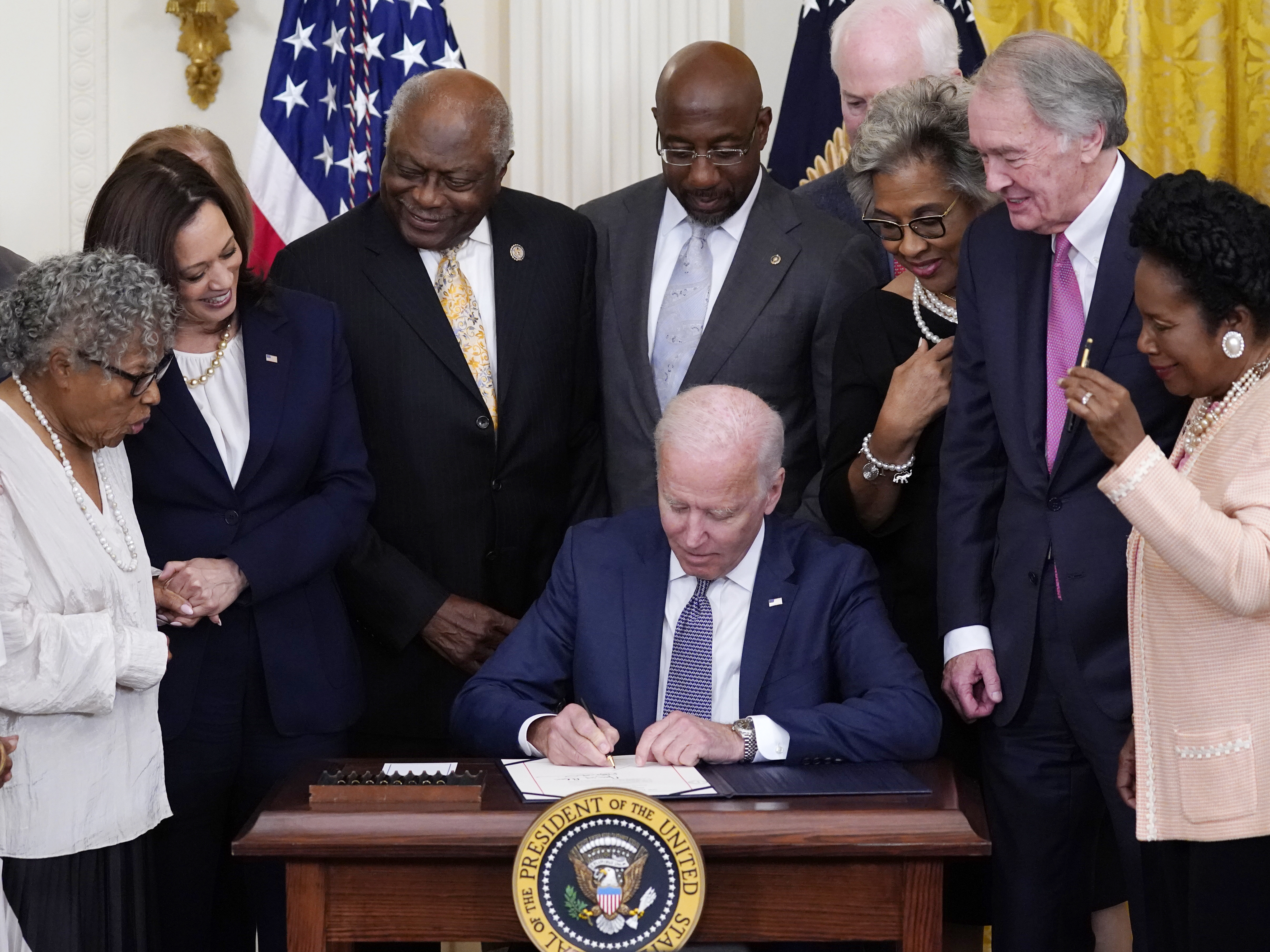 caption: President Joe Biden signs the Juneteenth National Independence Day Act in the East Room of the White House.