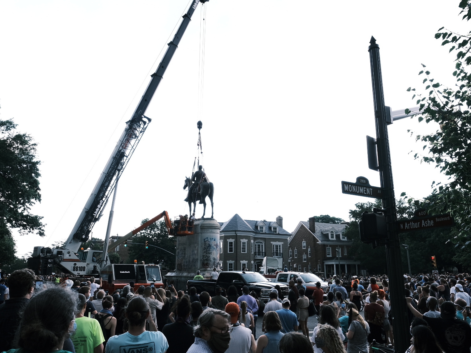 caption: A crowd watches as a crane removes the Stonewall Jackson Monument in Richmond, Va., on July 1. Dozens of Confederate monuments have come down this summer.