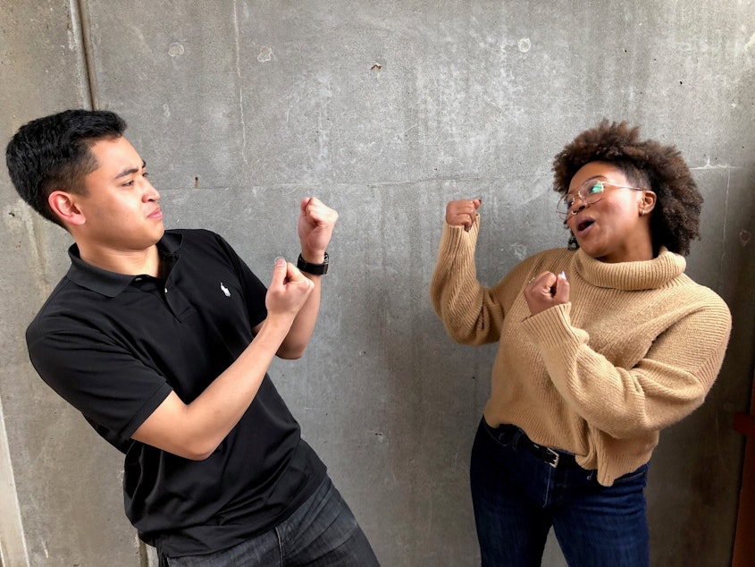 caption: Joe Santiago and Ishea Brown of KUOW's Curiosity Club pretend to fight at KUOW Public Radio station in Seattle on March 25, 2019. 