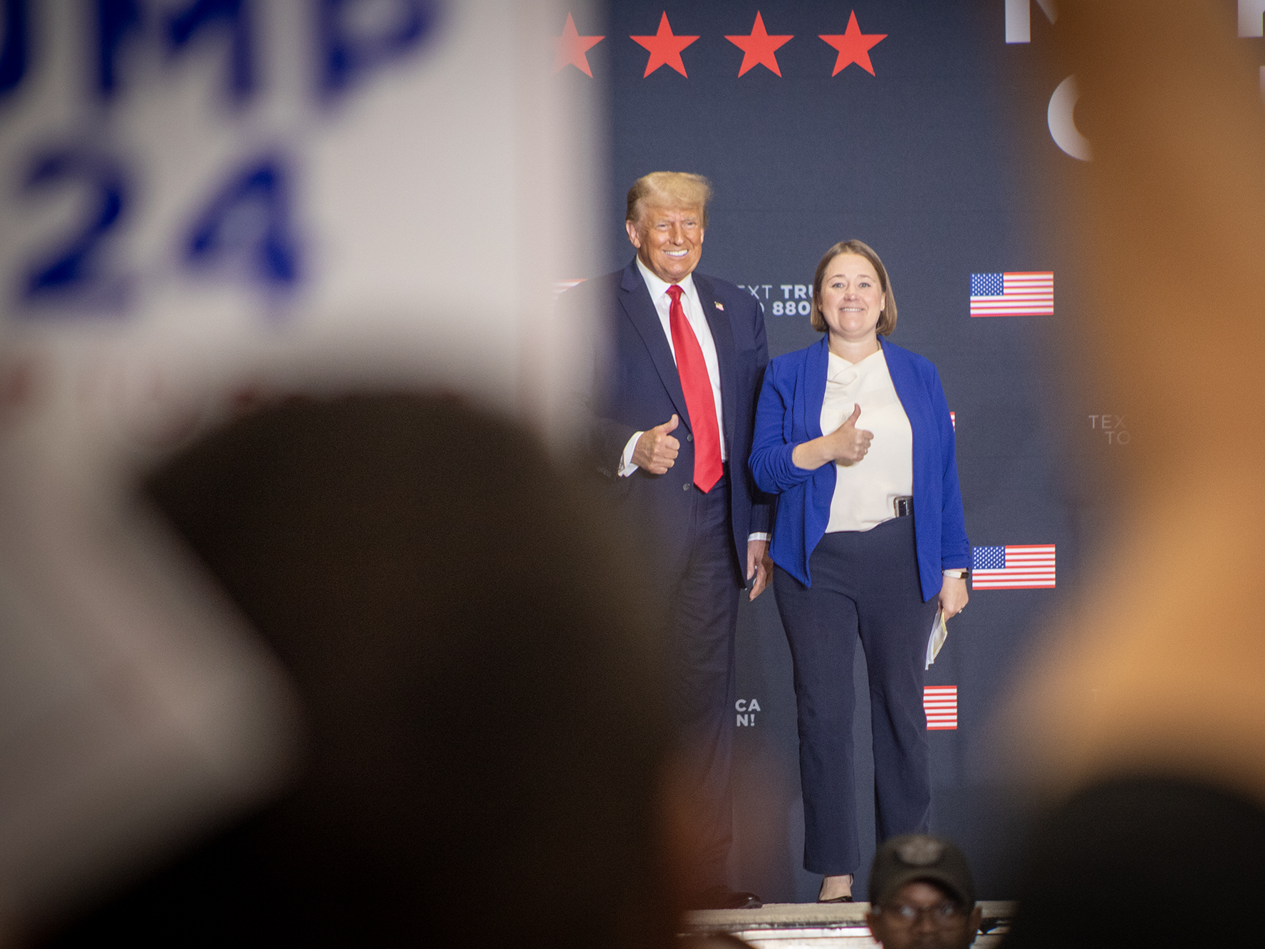 caption: Former President Donald Trump stands on stage during a rally in suburban Des Moines with Iowa Attorney General Brenna Bird after receiving her endorsement on Oct. 16.