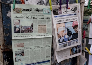 caption: This picture taken on November 8, 2020 shows a view of international Arabic newspaper Asharq Al-Awsat (L) and Lebanese newspaper al-Akhbar (R) along a stand in Lebanon's capital Beirut, with headlines featuring the 2020 US general election results. (ANWAR AMRO/AFP via Getty Images)