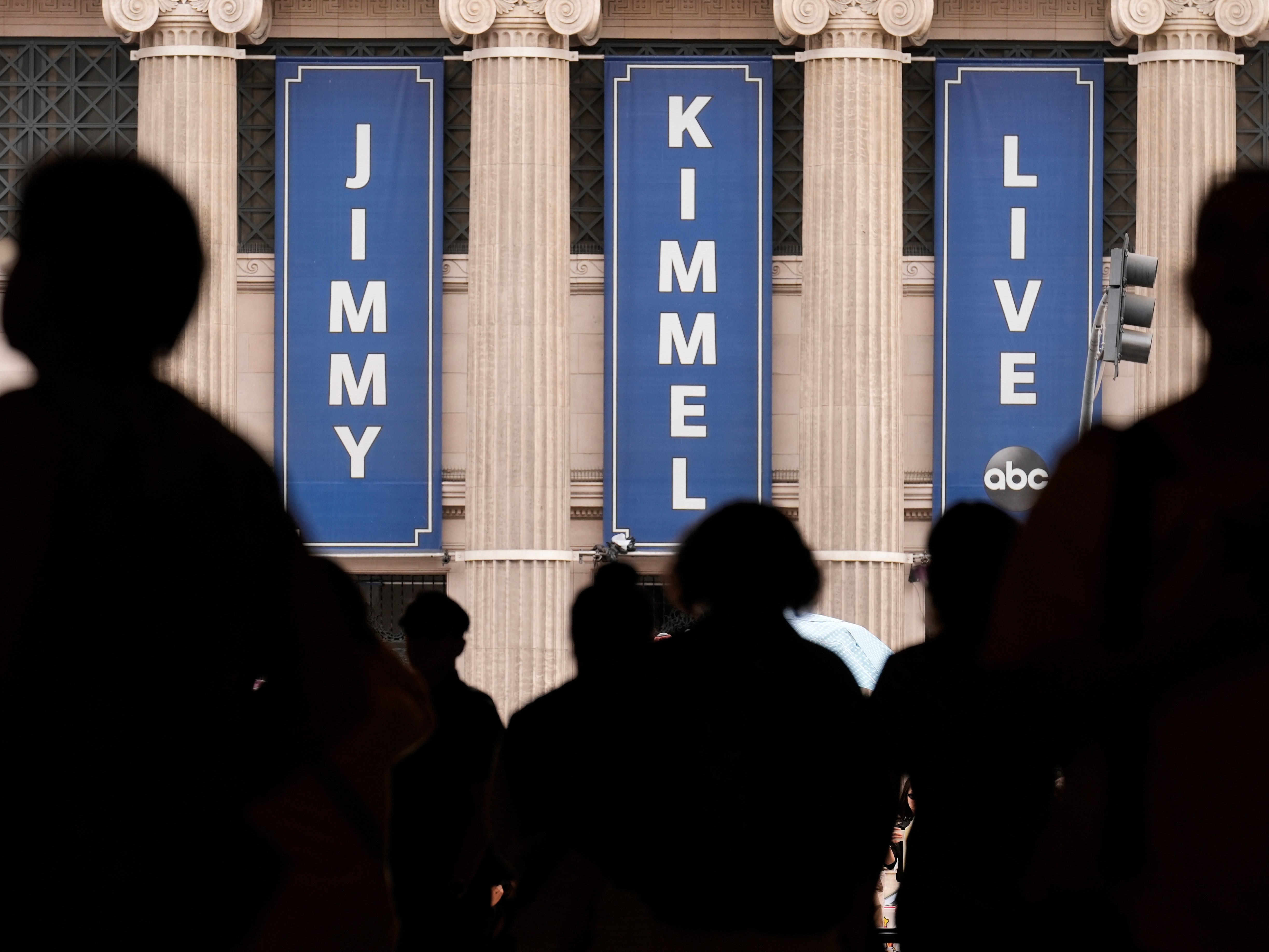 caption: FILE - People walk by the Jimmy Kimmel Live studio on Hollywood Blvd., on Sept. 17, 2025, in Los Angeles.
