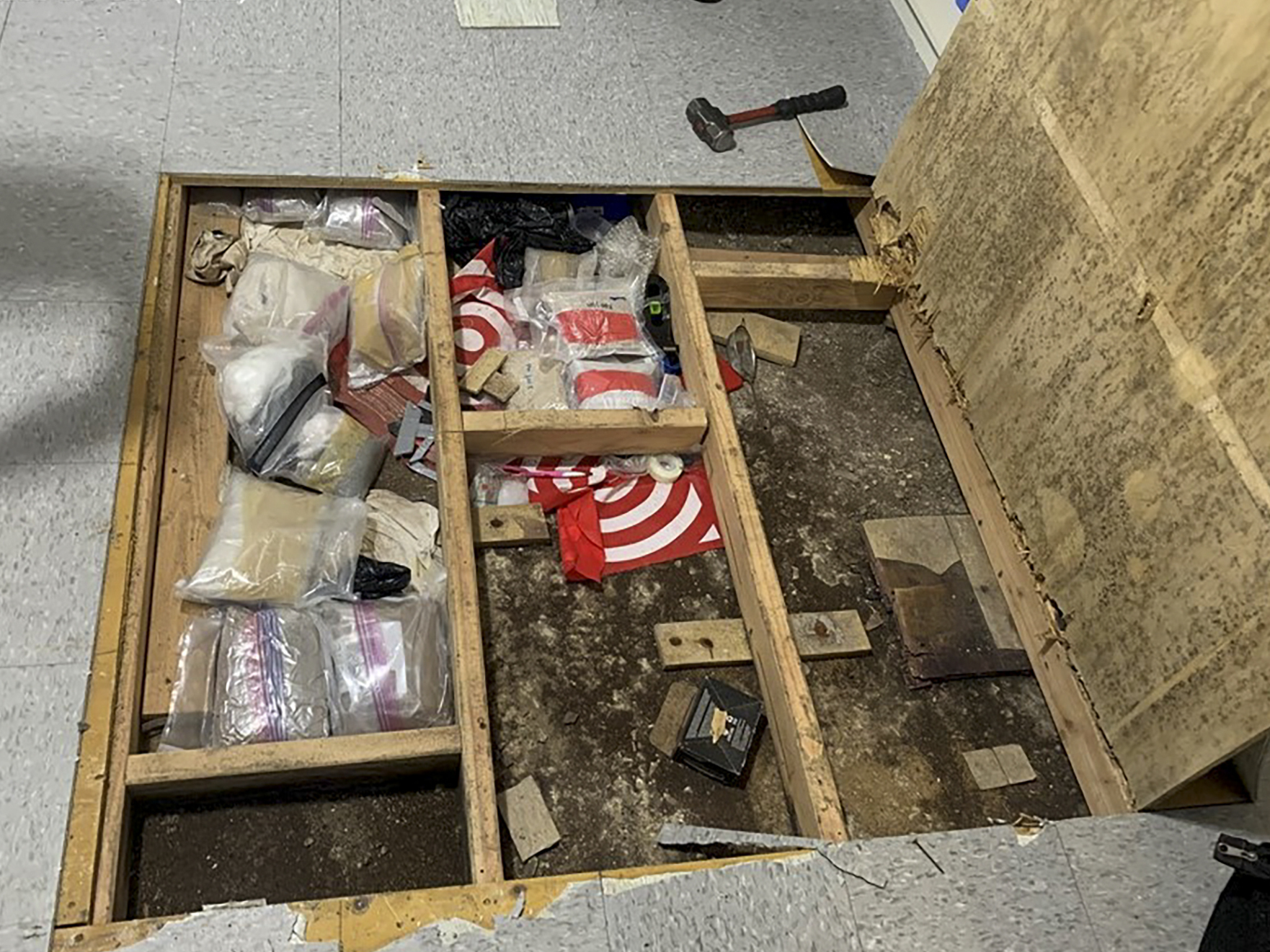 caption: In this photo provided by the New York City Police Department, a trap door leans open over narcotics, including fentanyl, and drug paraphernalia stored in the floor of a day care center, Thursday, Sept. 21, 2023, in New York.