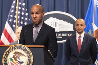 caption: Under Secretary of the Treasury for Terrorism and Financial Intelligence Brian Nelson, with U.S. Attorney Matthew Graves for the District of Columbia, speaks during a news conference on Tuesday at the Department of Justice in Washington.
