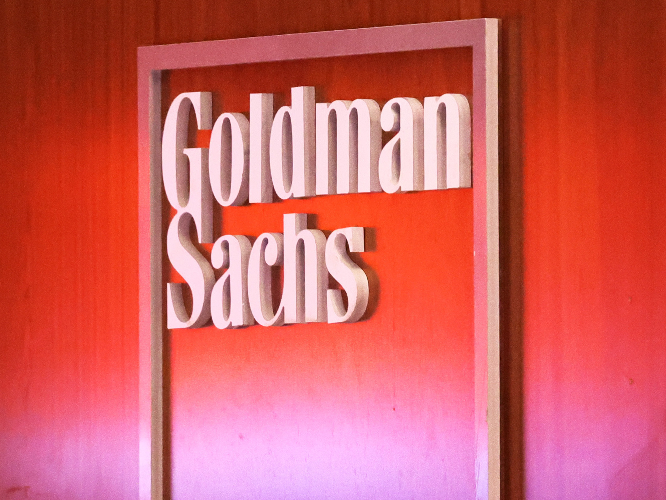 caption: The Goldman Sachs logo is seen at the New York Stock Exchange in New York City on Sept. 13, 2022. Goldman is laying off up to 3,200 employees as it faces a more challenging business environment.