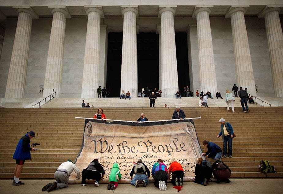 caption: Volunteers help roll up a giant banner printed with the Preamble to the United States Constitution during a demonstration against the Supreme Court's Citizens United ruling at the Lincoln Memorial on the National Mall October 20, 2010 in Washington, DC. The rally at the memorial was organized by brothers Laird and Robin Monahan who spent the last five months walking from San Francisco, California, to Washington to protest the court decision, which overturned the provision of the McCain-Feingold law barring 