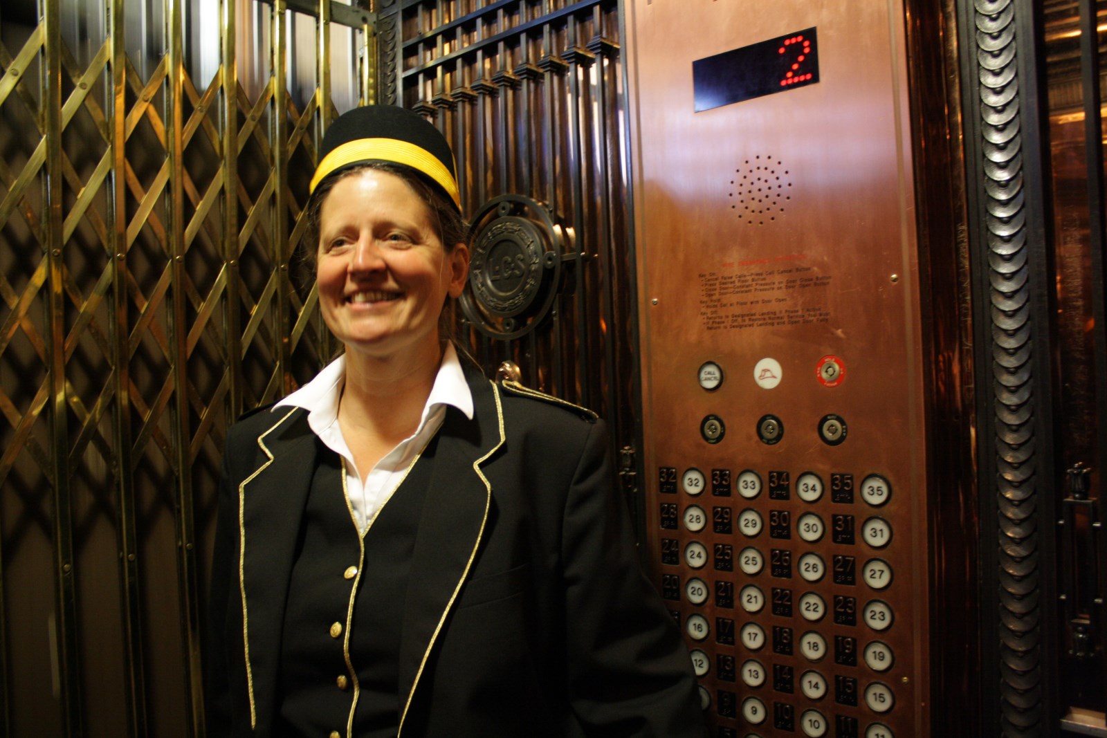 caption: Lesley Holdcroft operates the elevator at Seattle's historic Smith Tower. 