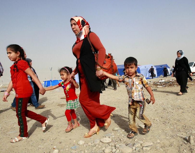 caption: Refugees fleeing from Mosul head to the self-ruled northern Kurdish region in Irbil, Iraq on Thursday, June 12.