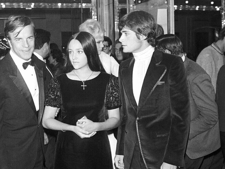 caption: "Romeo & Juliet" actors Olivia Hussey, center, and Leonard Whiting, right, are seen in September 1968 with director Franco Zeffirelli after the Parisian premier of the film.