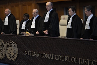 caption: Presiding judge Nawaf Salam (fourth from left) arrives to read a decision at the International Court of Justice in The Hague, Netherlands, Tuesday.