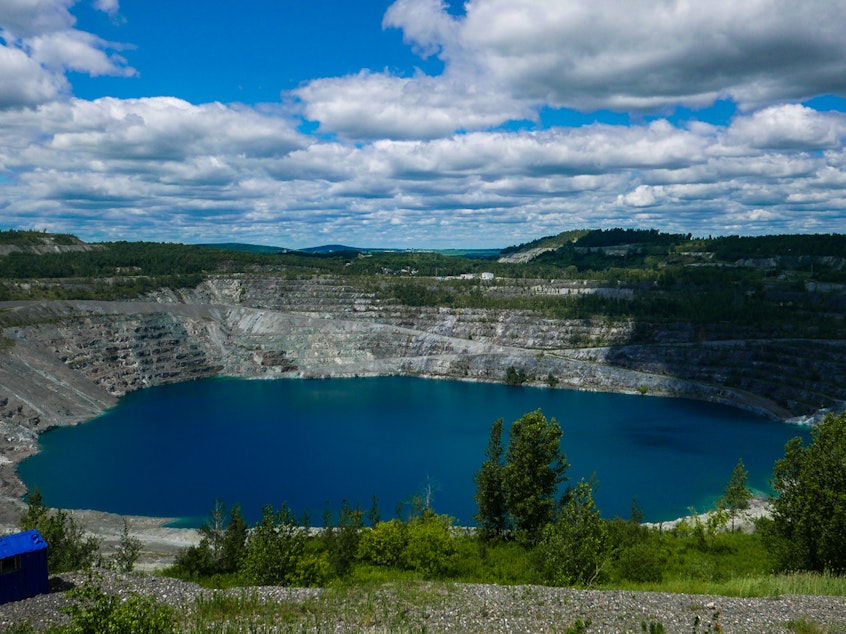 caption: A photo taken in July shows what's left of the Jeffrey asbestos mine in Asbestos, Quebec. The town has voted to change its name to Val-des-Sources.