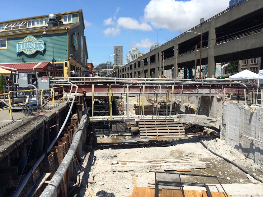 caption: The seawall replacement remains incomplete in front of waterfront shops and restaurants. Work is scheduled to resume this October. 