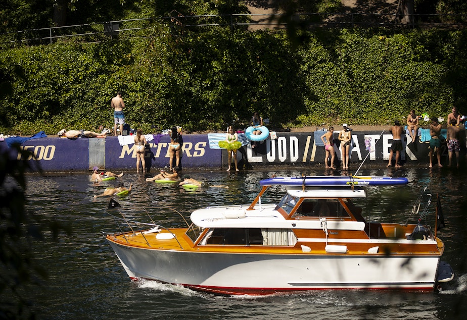 caption: Montlake Cut was a popular place for boaters and swimmers to cool off as temperatures reached 90 degrees on Tuesday, July 26, 2022, in Seattle. 