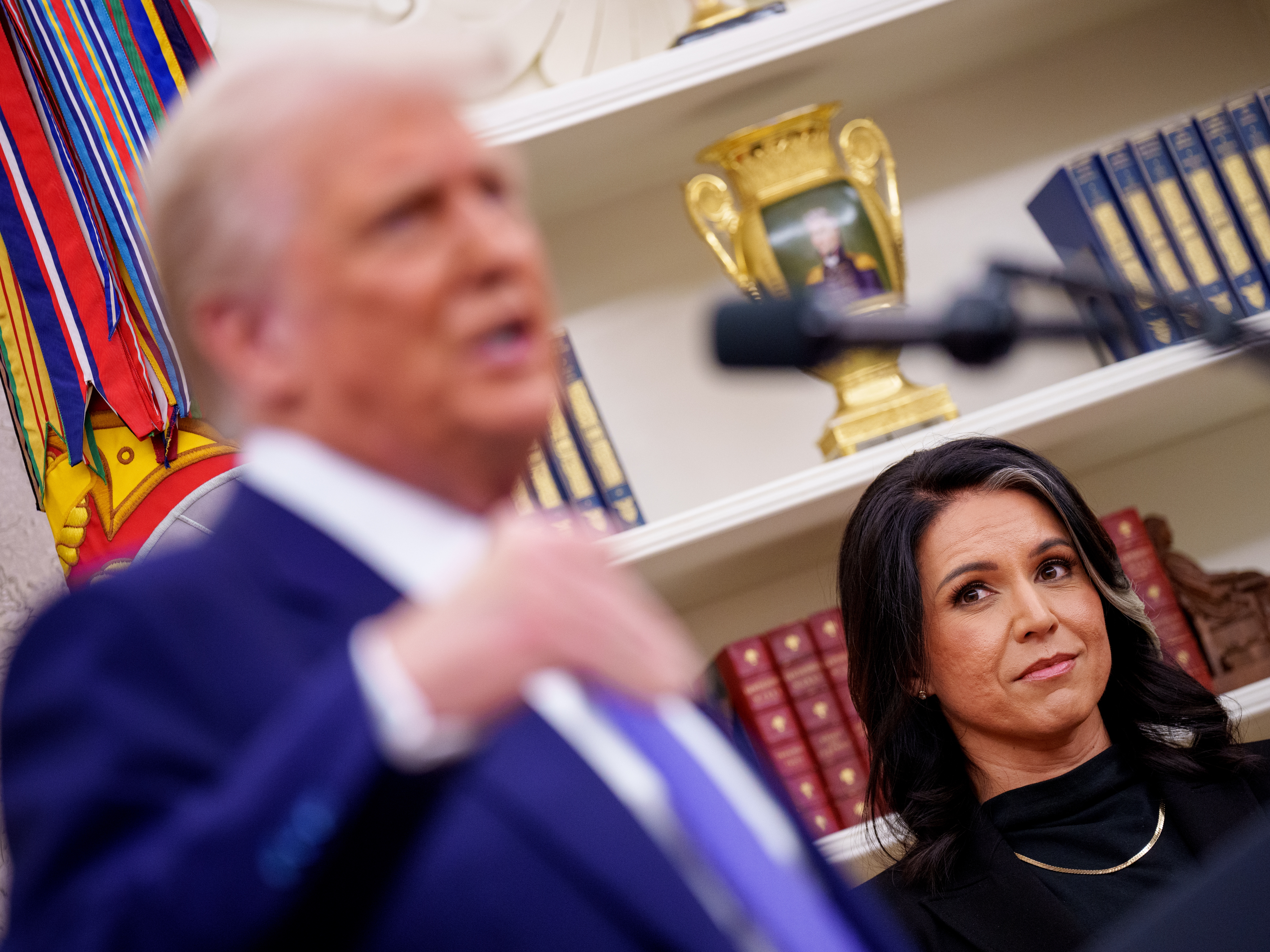 caption: President Trump, accompanied by Tulsi Gabbard, speaks after Gabbard is sworn in as director of national intelligence on February 12.