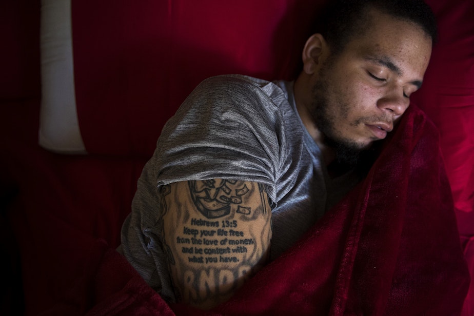 caption: DaShawn Horne rests in his new bedroom on the first floor after spending 103 nights at Harborview Medical Center on Thursday, May 3, 2018, at his home in Auburn. (This story was first published in 2019). 