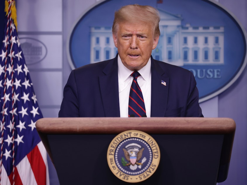 caption: President Trump speaks during a news conference at the White House on July 30. On Saturday, Twitter and Facebook both flagged posts from the president that encouraged Americans to vote by mail and then go to the polls on Election Day to check that their vote was counted.