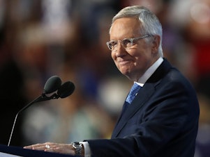 caption: Then-Senate Minority Leader Harry Reid of Nevada smiles as he speaks during the third day of the Democratic National Convention in Philadelphia on July 27, 2016.