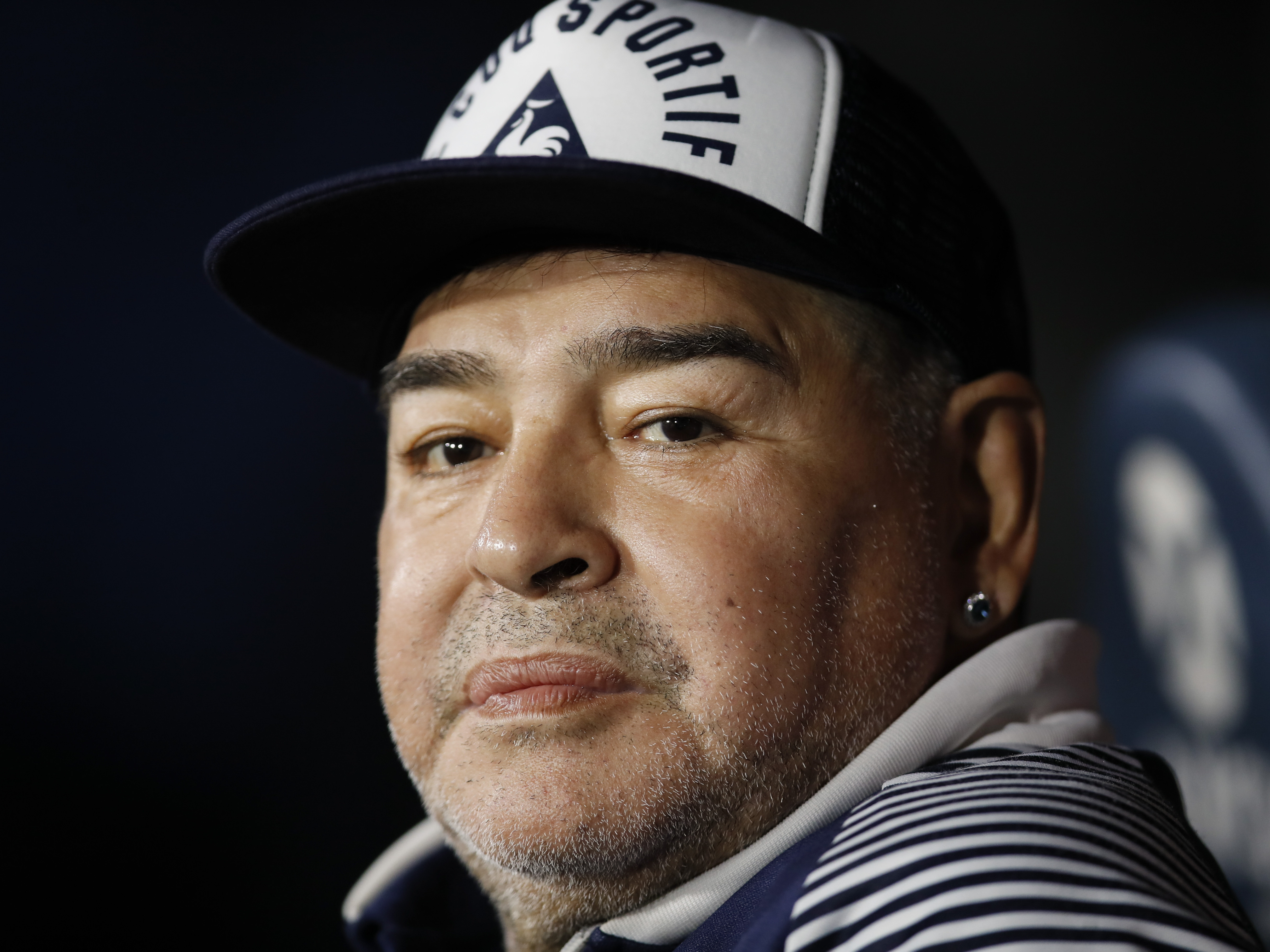 caption: In this March 7, 2020 file photo, Diego Maradona, coach of Gimnasia y Esgrima, sits on the bench prior to Argentina's soccer league match against Boca Juniors at La Bombonera stadium in Buenos Aires, Argentina.