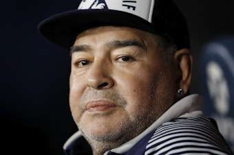caption: In this March 7, 2020 file photo, Diego Maradona, coach of Gimnasia y Esgrima, sits on the bench prior to Argentina's soccer league match against Boca Juniors at La Bombonera stadium in Buenos Aires, Argentina.