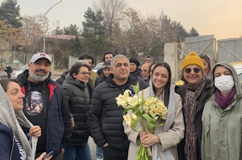 caption: Prominent Iranian actress Taraneh Alidoosti (center) holds flowers as she poses for a photo among her friends after being released from Evin prison in Tehran, Iran, on Wednesday.