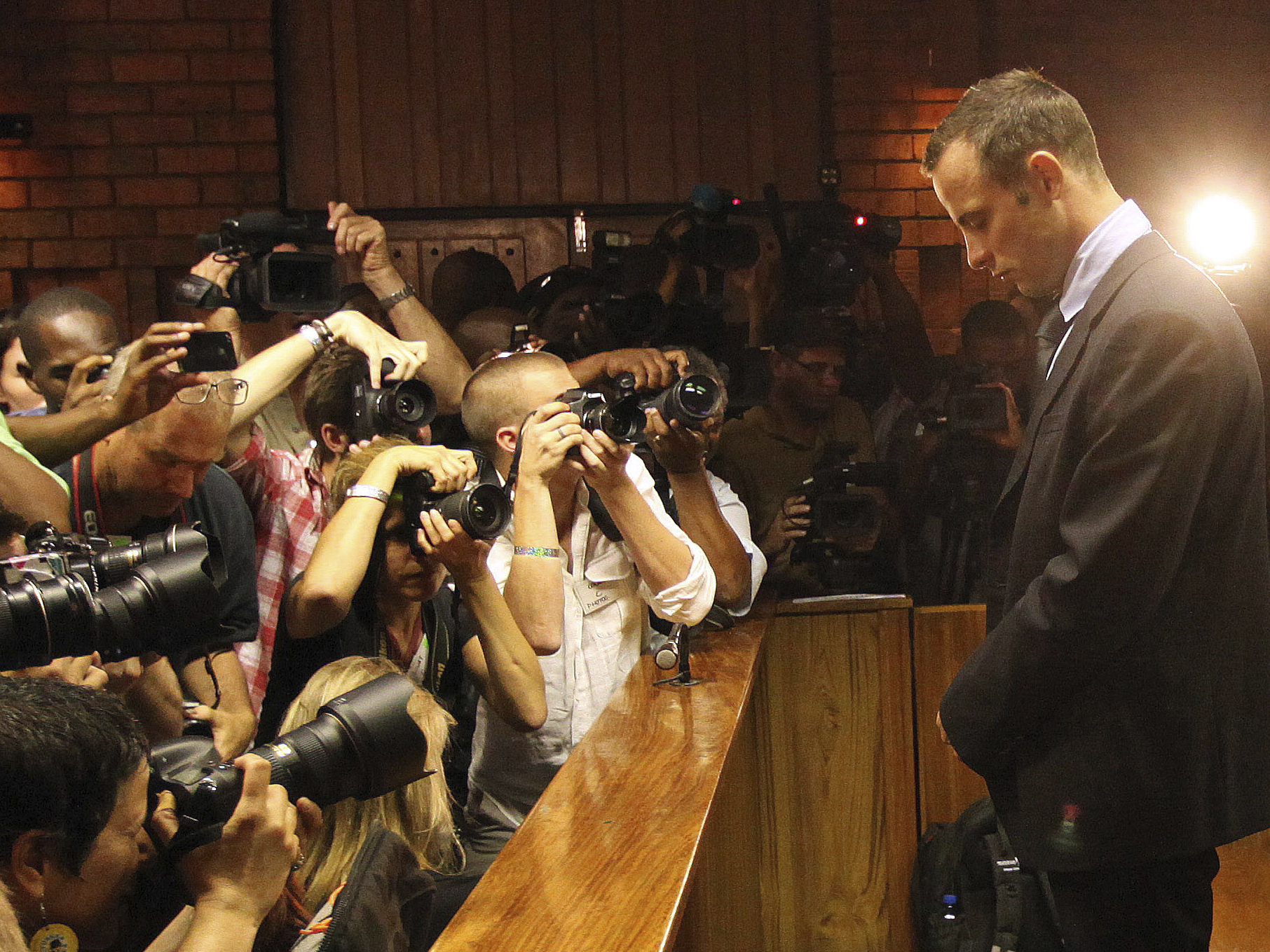caption: Photographers take photos of Olympic athlete Oscar Pistorius as he appears at a bail hearing for the shooting death of his girlfriend Reeva Steenkamp, in Pretoria, South Africa, Feb 20, 2013. Eight years after he shot dead his girlfriend, Pistorius is up for parole, but first he must meet with her parents as part of the parole procedure.