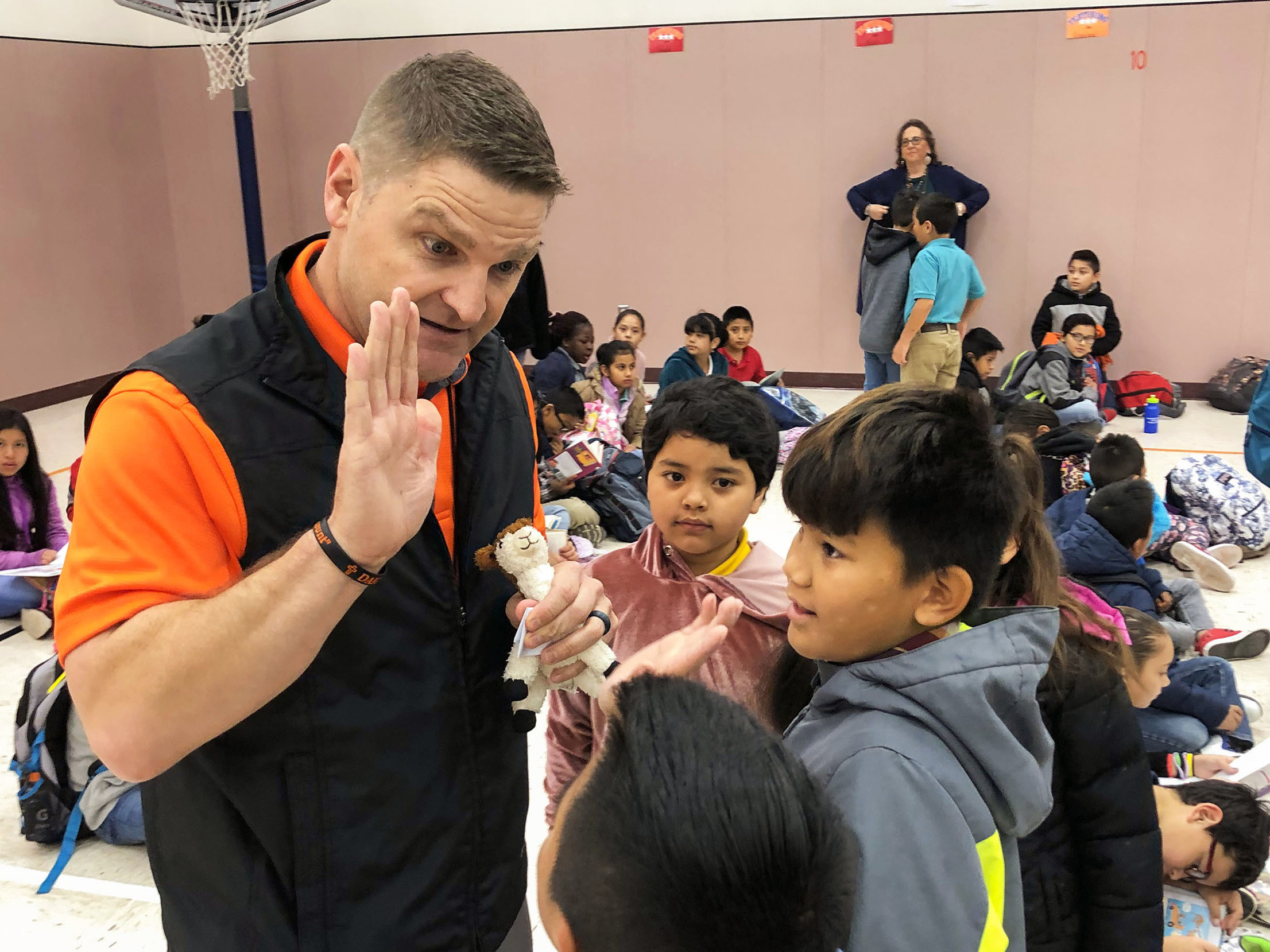 caption: Principal T.J. Funderburg welcomes his mostly immigrant students during morning assembly at Cactus Elementary School.