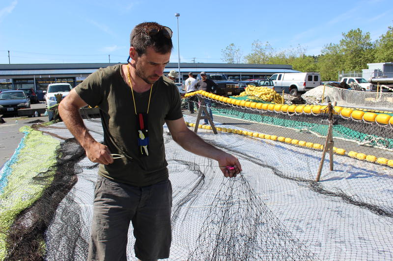 caption: Logan Price is a greenhorn on the Sea Gem this year. He said the crew of his boat will be working right up until the day they leave for Alaska where they will spend the summer salmon fishing. Their pay day depends on how much they can catch.
