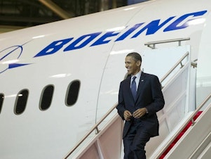 caption: Then-President Barack Obama walks down the stairs of a Boeing 787 Dreamliner at the company's production facility in Everett, Wash., in 2012.