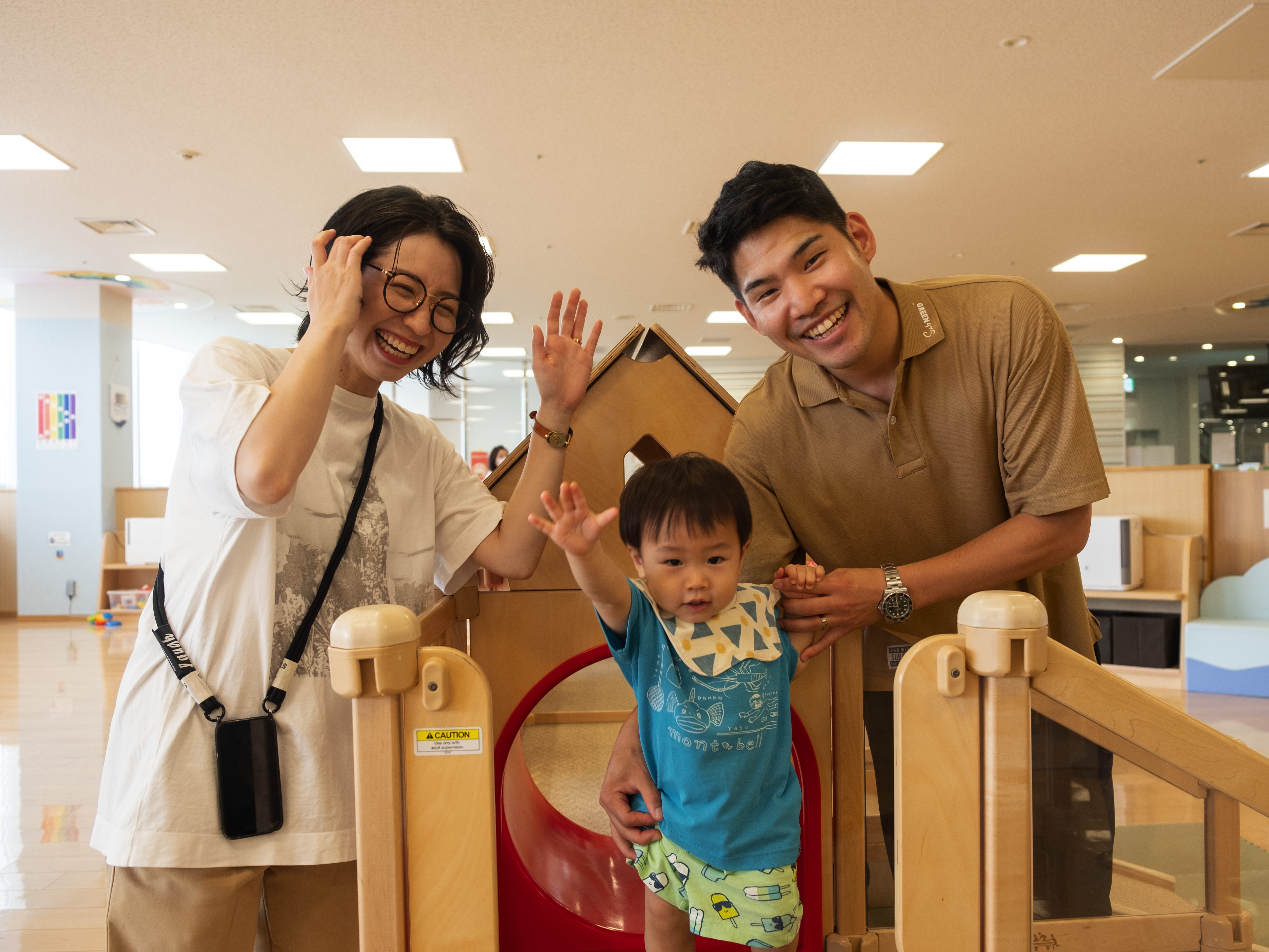 caption: Taiki and Arisa Chisaka watch as their son Tatara plays at a city-run child care center in western Japan's Akashi city.