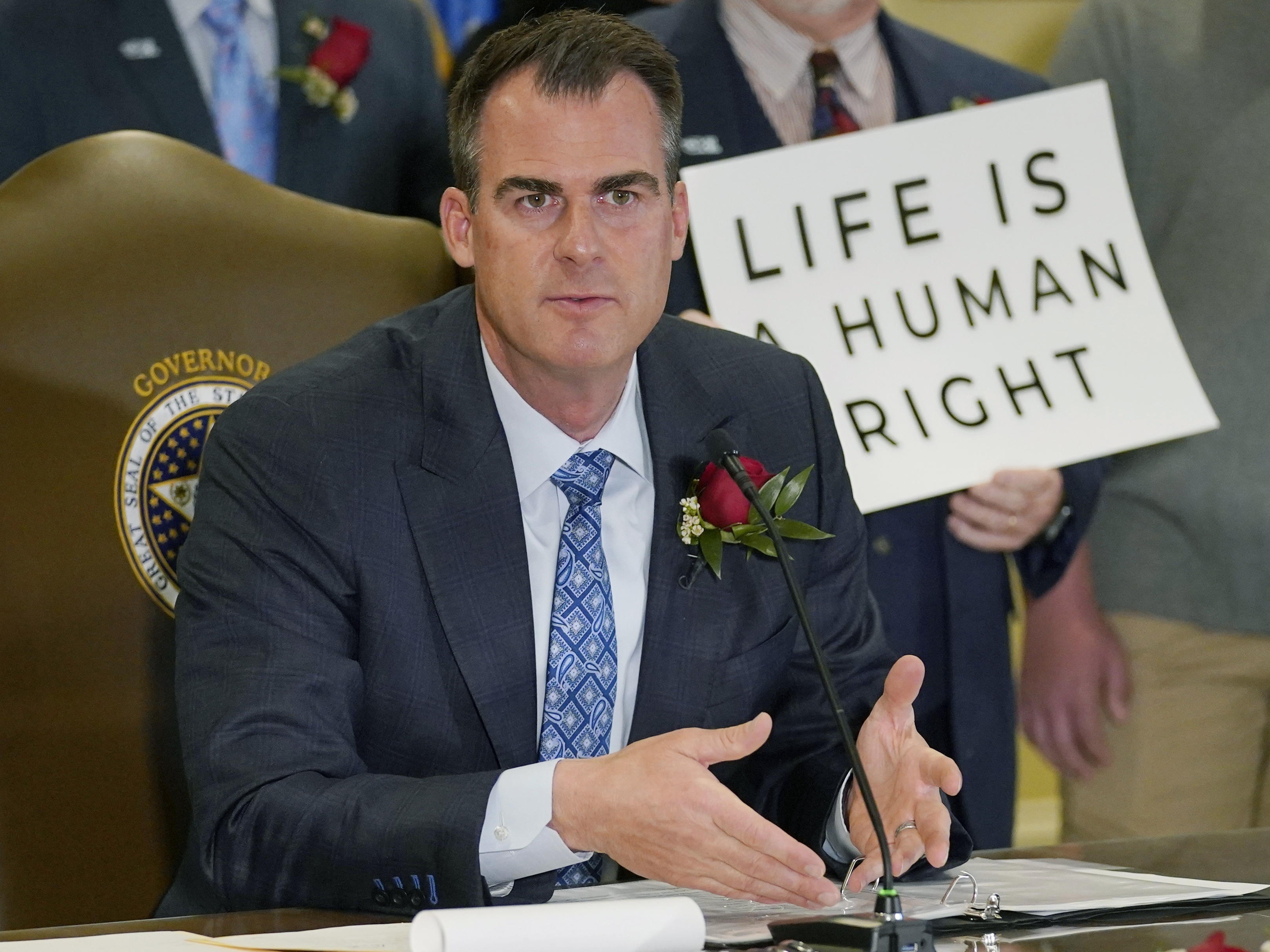 caption: Oklahoma Gov. Kevin Stitt speaks after signing into law a bill making it a felony to perform an abortion, punishable by up to 10 years in prison, on April 12, 2022, in Oklahoma City.