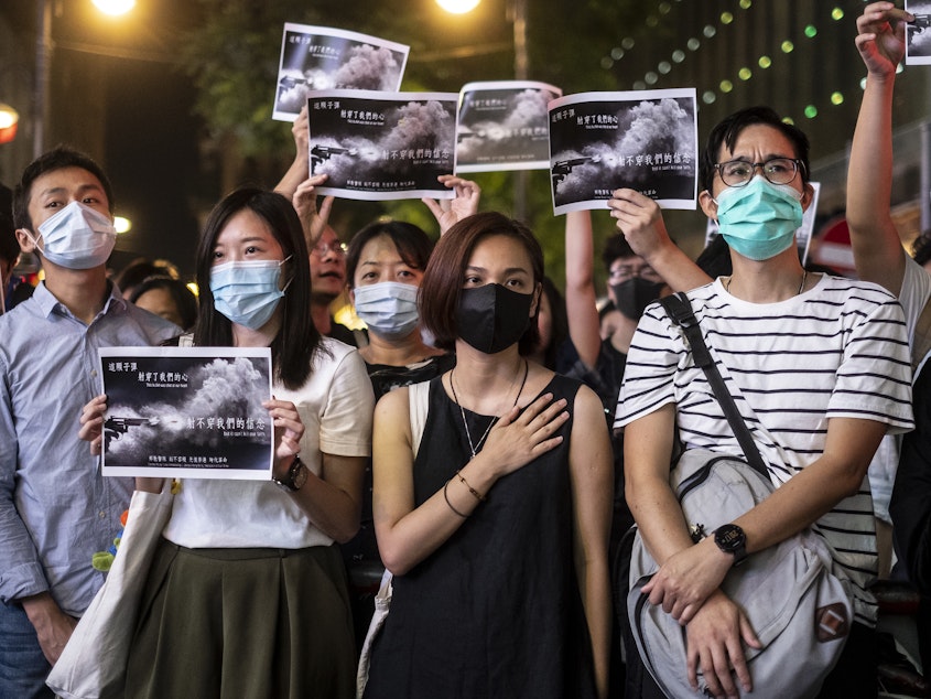 caption: Hong Kong's government is set to invoke emergency powers it hasn't used in more than 50 years, as it moves to ban face masks. Here, demonstrators stand in Hong Kong's Causeway Bay to protest the police shooting of a young demonstrator.